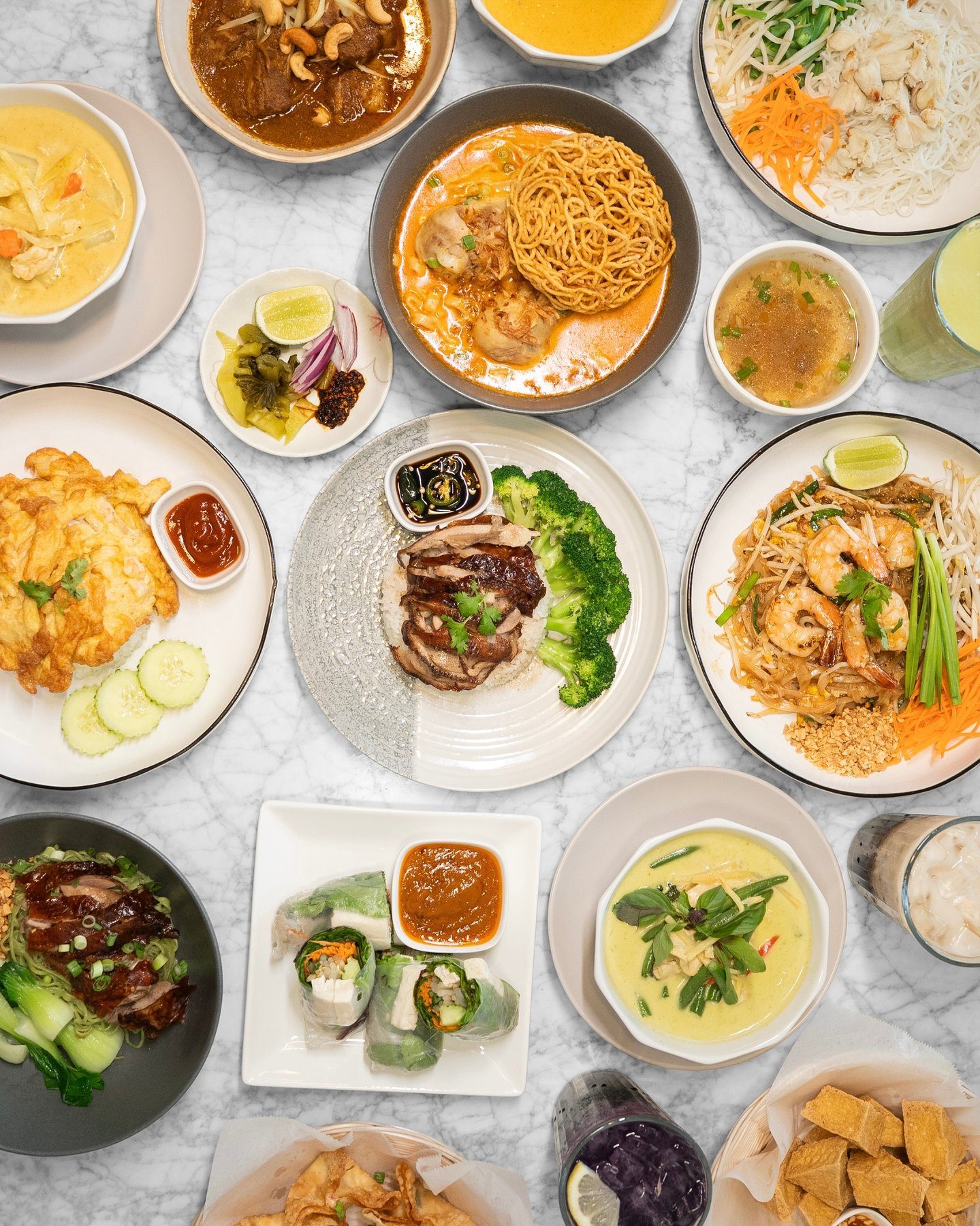 Overhead of Thai dishes at Spelling Thai Bistro: curries, noodles, rice plates, and spring rolls